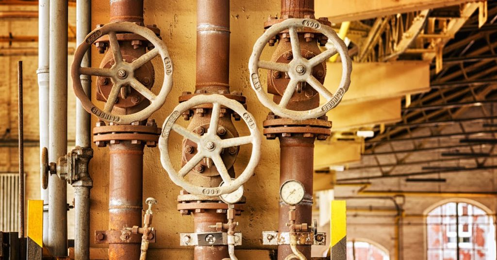 Close-up of rusty industrial pipes and valves, showcasing aging machinery in a factory setting. Finding connection